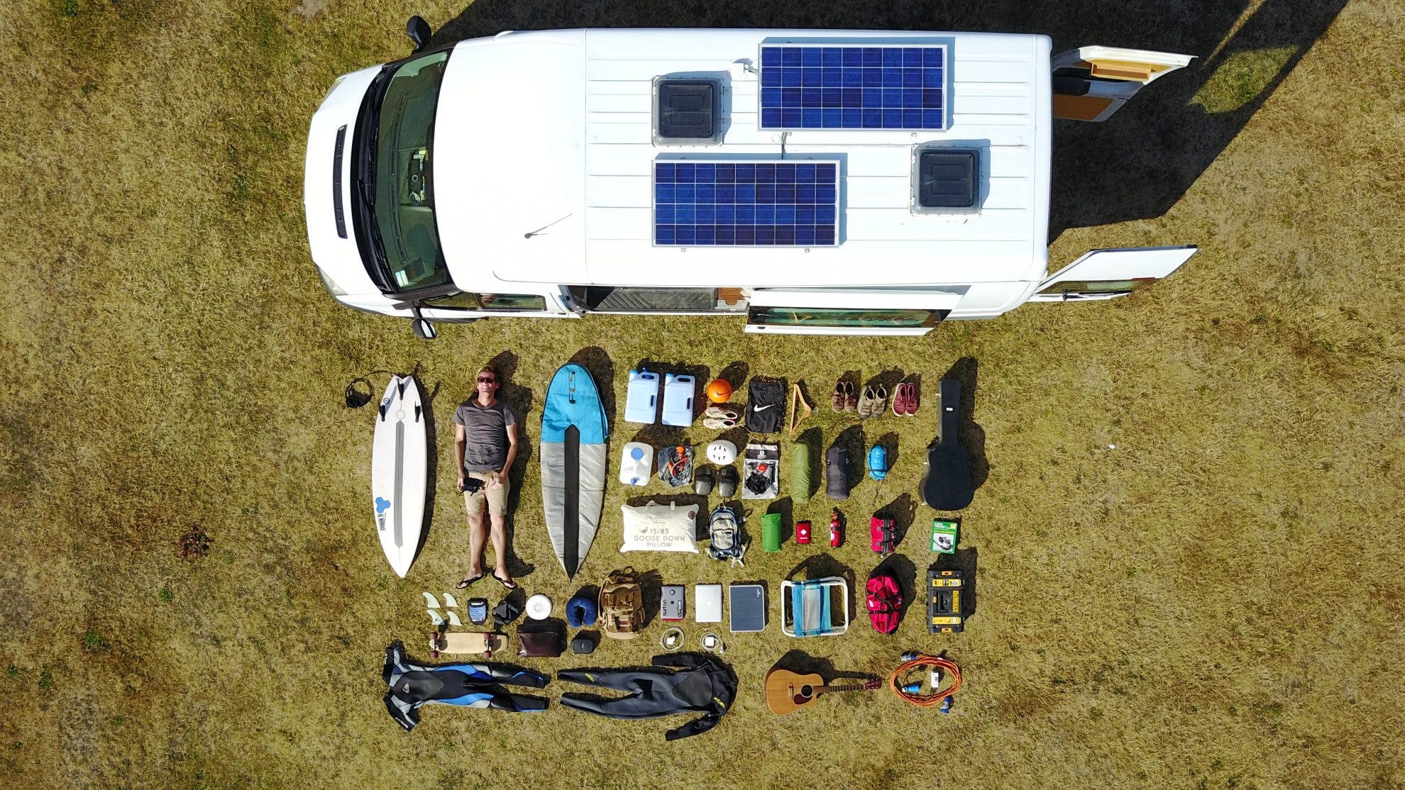 all the contents of a person's items in a van, shown outside of the van for perspective exemplifying minimalist nature of vanlife